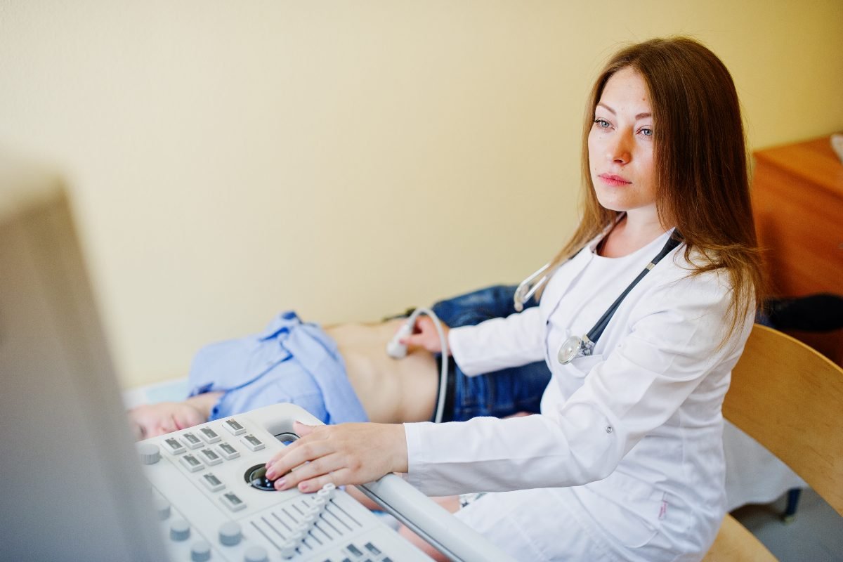 Ultrasound technician performing a medical scan in a modern hospital